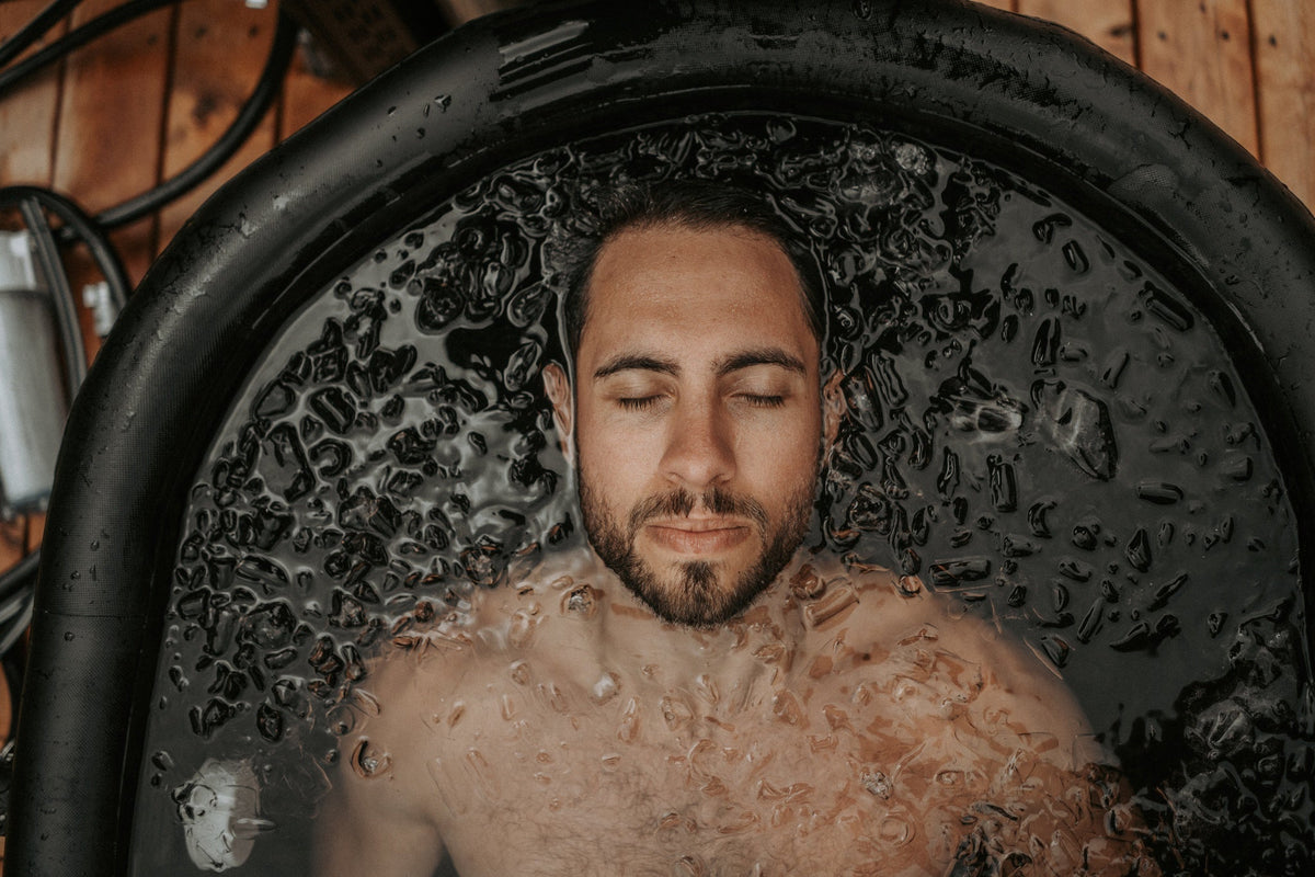 Homme immergé dans l'eau glacée d'un bain froid OASIS, vue du dessus