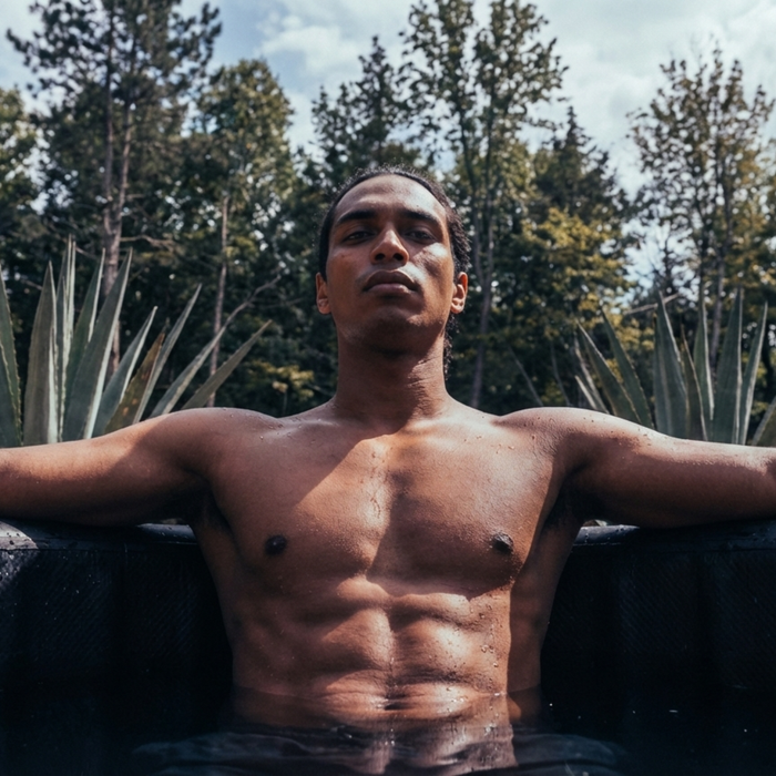 Homme détendu dans un bain froid, bras posés sur le rebord