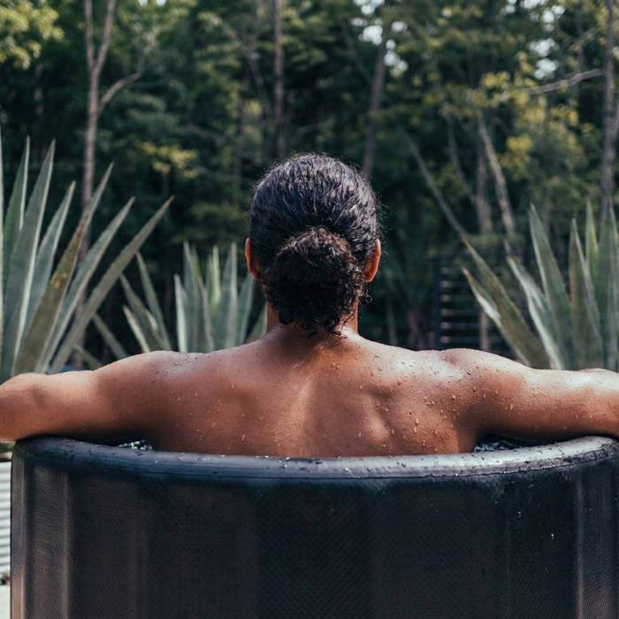 Homme de dos dans un bain froid au milieu du jardin