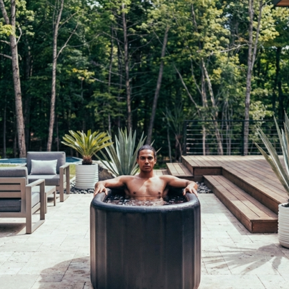 Homme dans le bain froid OASIS sur une terrasse de jardin